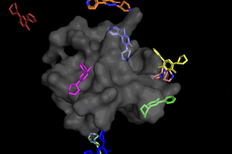 A large, 3D gray mass surrounded by smaller molecules in various colors.
