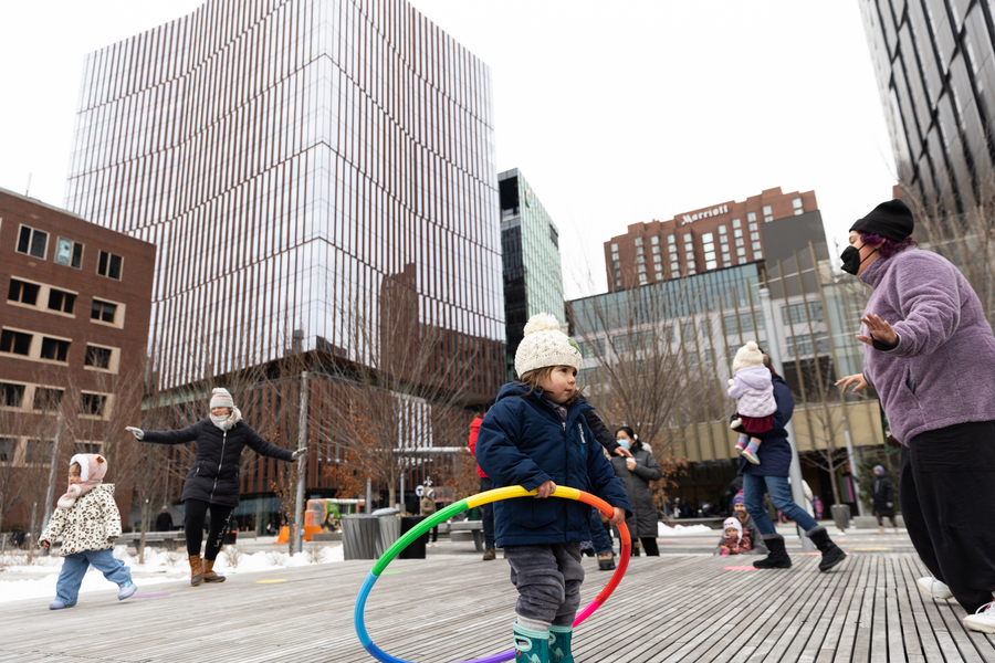 Children dancing with hula hoops on an outdoor stage