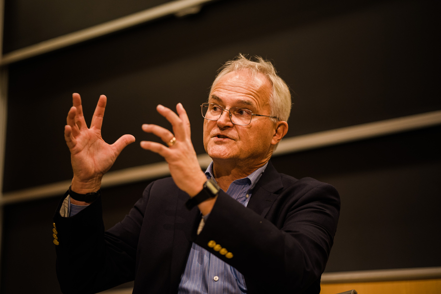 Photo of Bror Saxberg speaking in front of a blackboard and gesturing with his hands.