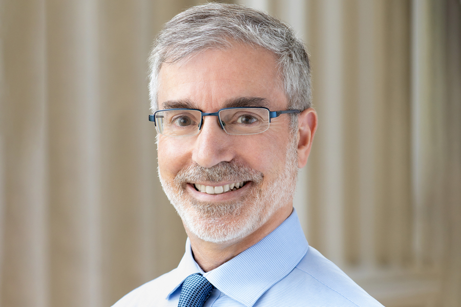 Portrait photo of Stuart Schmill, with columns in background