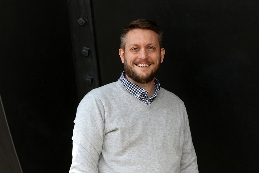 Portrait photo of Benjamin Mangrum standing before a black background