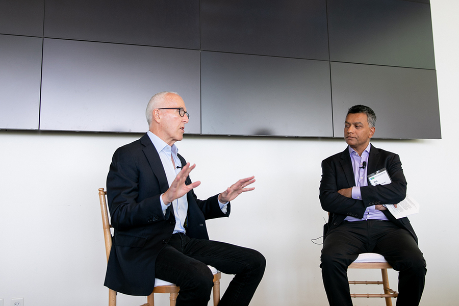 Photo of Frank McCourt (left) and Deb Roy (right) facing each other, seated, in discussion