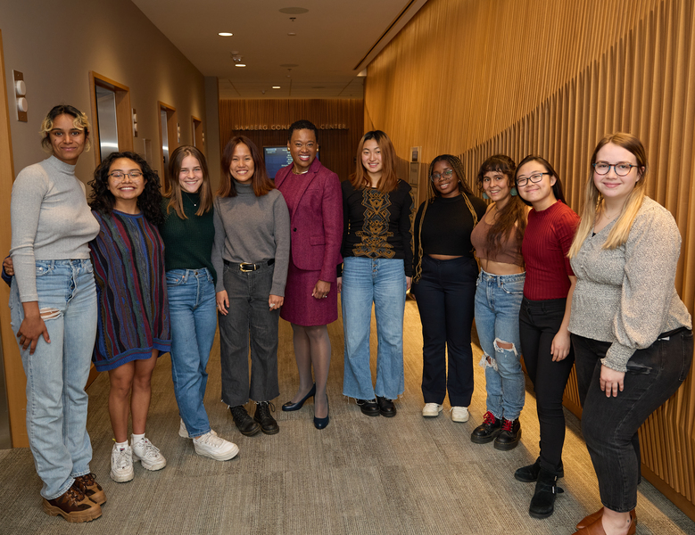 Nine award winners standing indoors in an arc with Melissa Nobles in the center