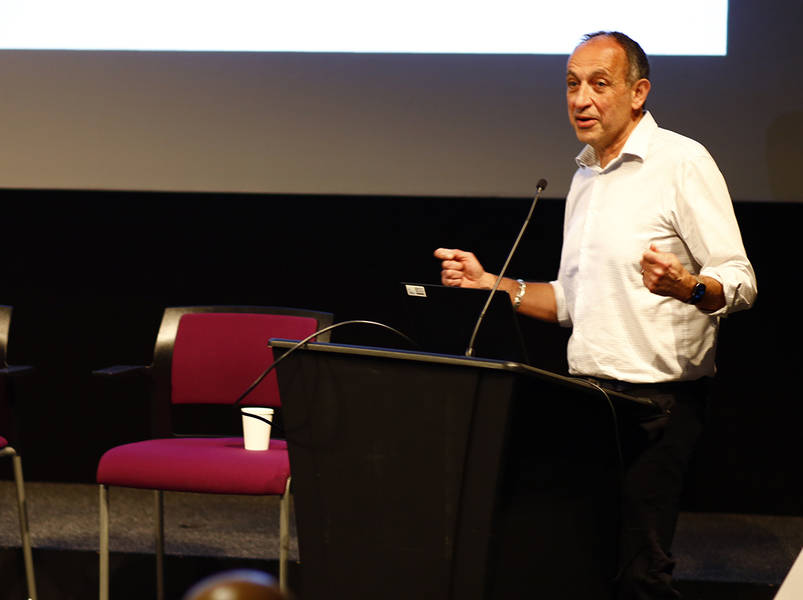 Munther Dahleh speaks at a podium in an indoor space