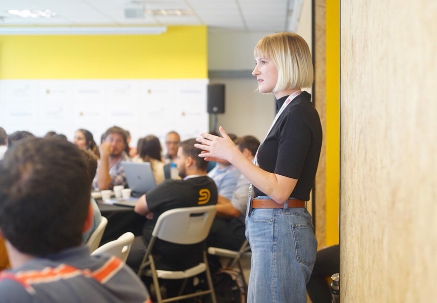 Taylor Baum stands in front of classroom, teaching students