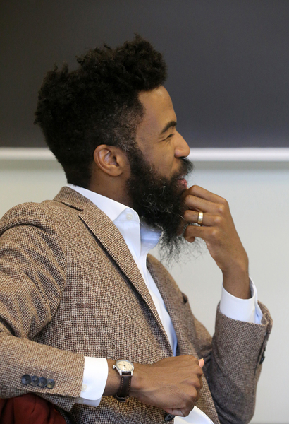Joshua Bennett, pictured in profile, is seated in front of a blackboard