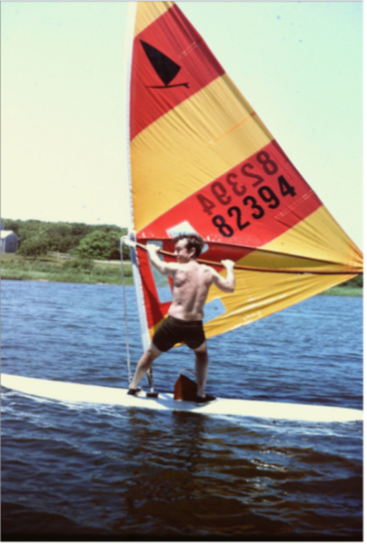 Man on windsurfer with a colorful sail.