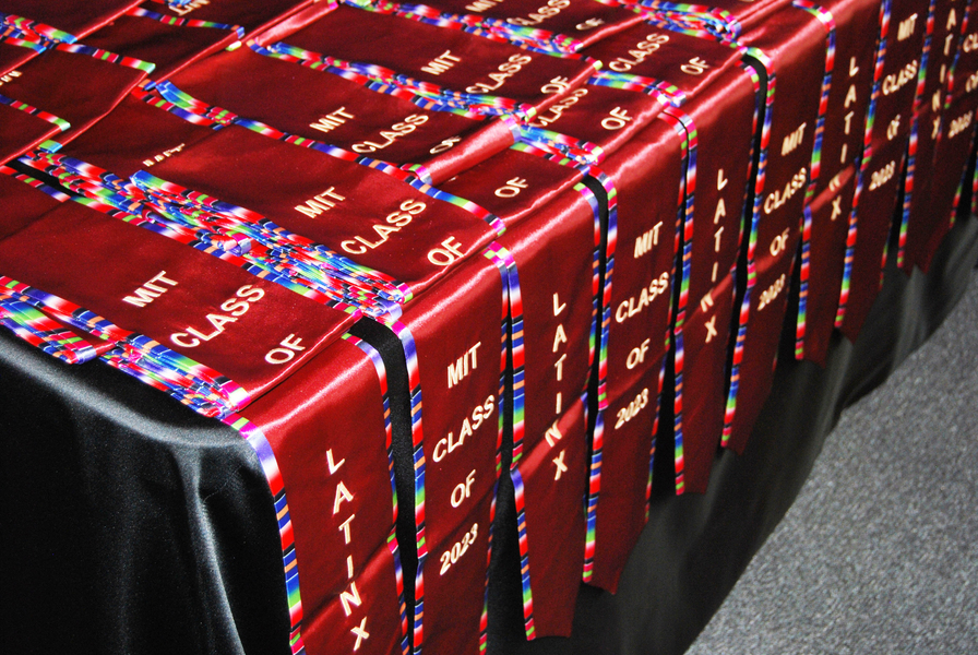 Red Latinx stoles draped on a table. They say "LatinX MIT Class of 2023"