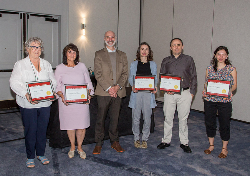 Agustin Rayo stands with five winners of the 2023 Infinite Mile Awards, each of them holding up their plaque for the camera