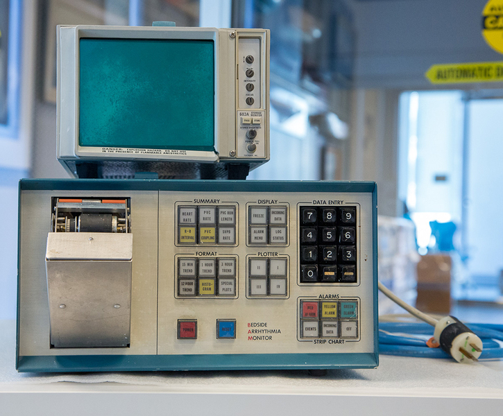 1970s arrhythmia detector is a metal box with 28 square buttons, a numeric keypad, and a small CRT monitor on top.