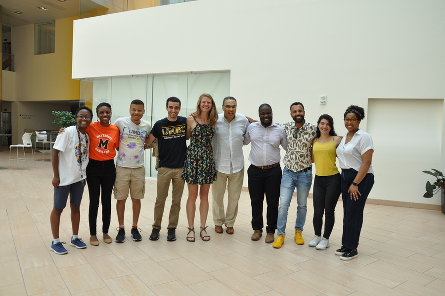 Group of 10 people standing in a line posing for a photo.