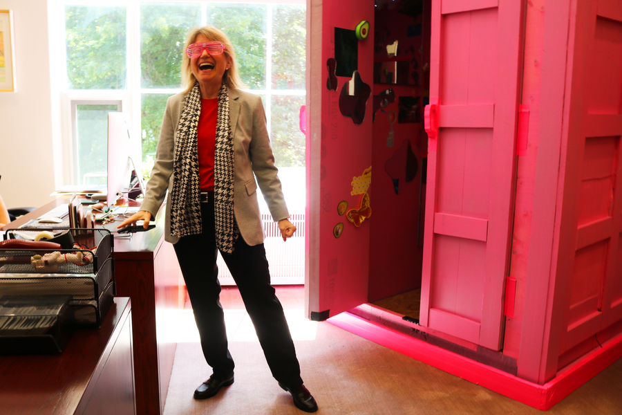 President Kornbluth laughing after putting on pink sunglasses, standing outside Barbis