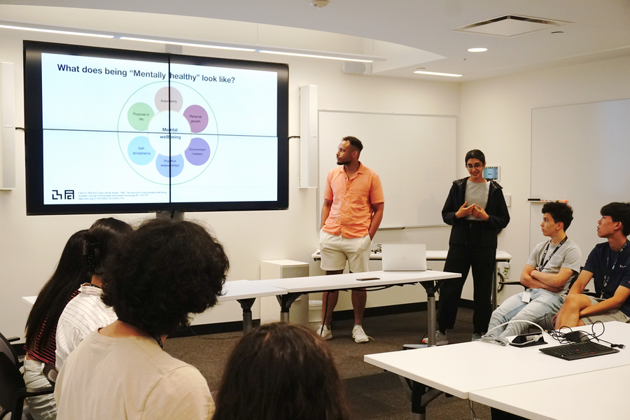 Noah Jones and Ila Kumar give a presentation to high school students in a classroom.