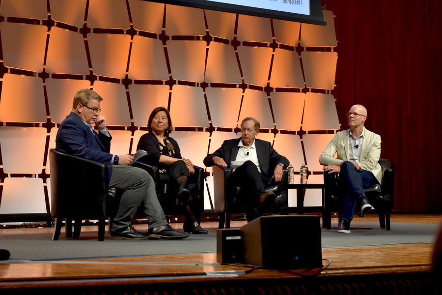 Four people seated together on a stage in discussion.