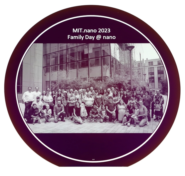 A circular silicon wafer displaying a group photo of 50 people.
