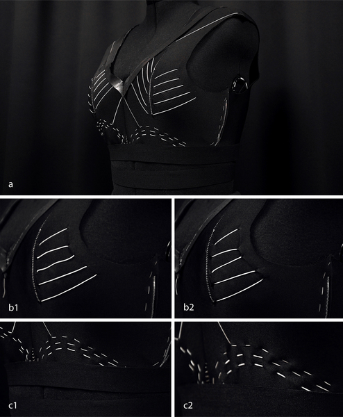 5 views of a sports bra are labeled “A, B1, B2, C1, C2.” The sports bra is mainly made of black fabric, but has white fabric at areas it could contract, like on the sides and under the chest.