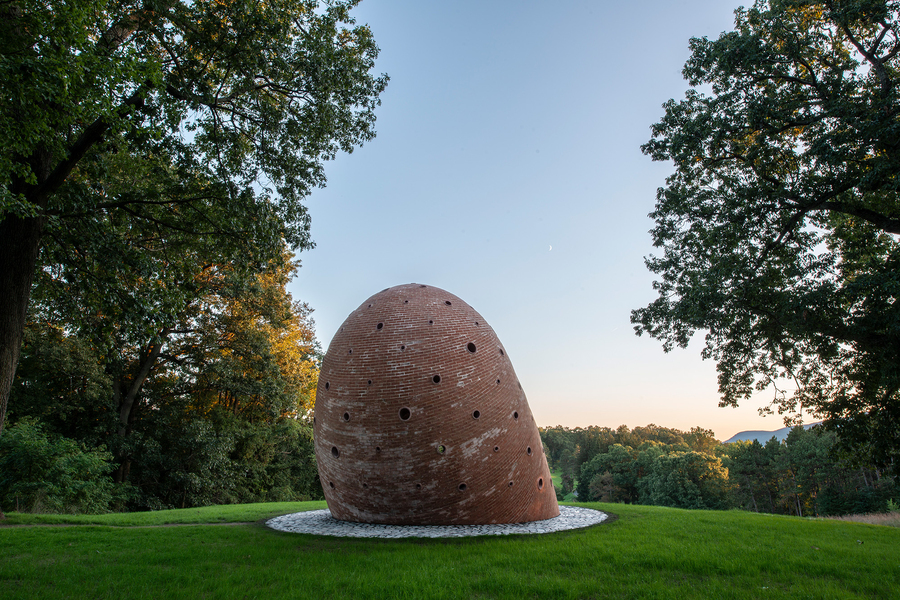 A view of the back of the brick sculpture, with a curved roof.