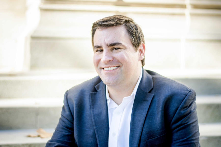 Headshot of Steven Barrett, who is sitting on concrete stairs