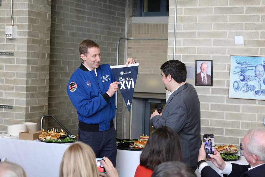 Woody Hoburg presenting Steven Barrett with a course 16 pennant he brought with him to the ISS.