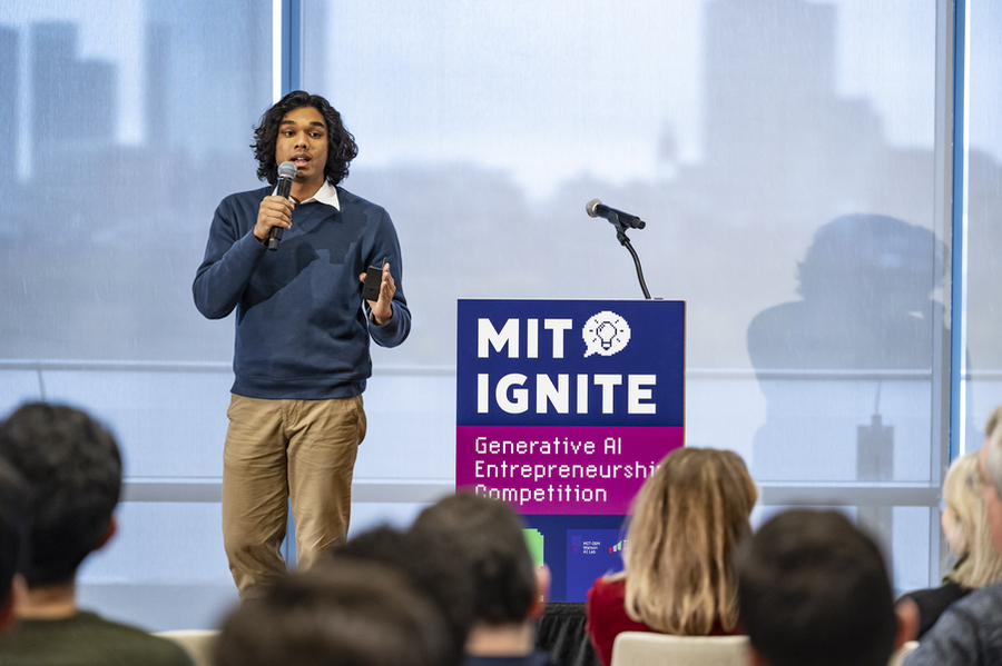 Ayush Nayak presents on stage near podium that reads "MIT Ignite"