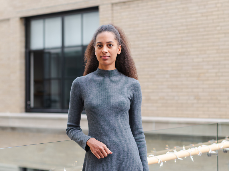 Morgane Konig stands in a long-sleeved gray knit dress in the Center for Theoretical Physics