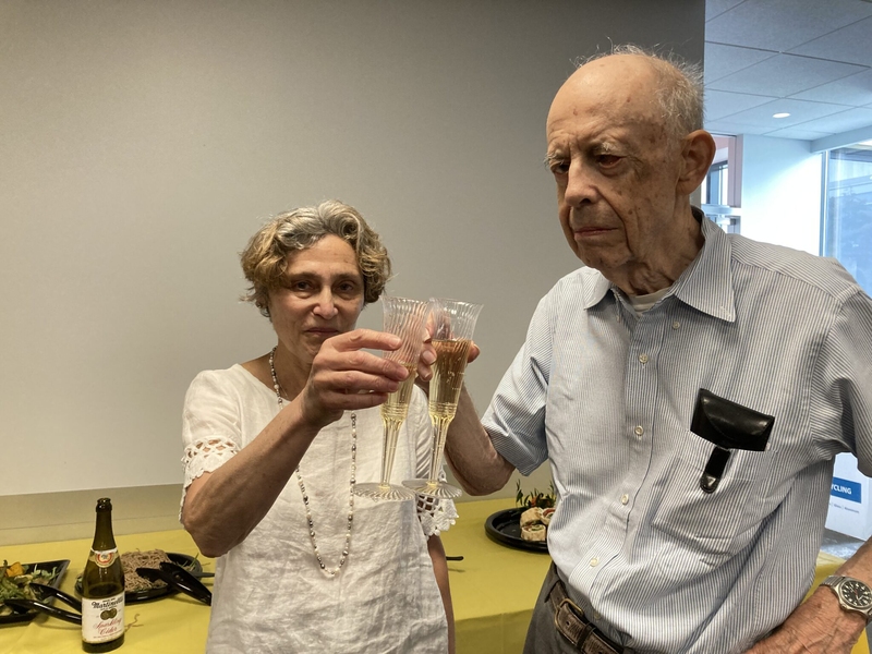 Helen Schwartz and Fred Hennie raise glasses of sparkling wine