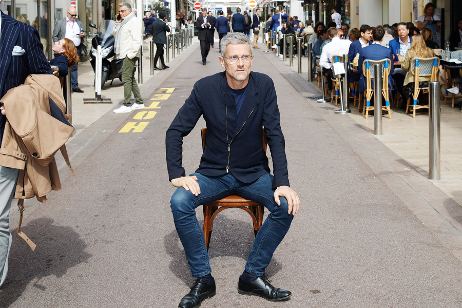 Carlo Ratti sits on chair in middle of busy street outside.