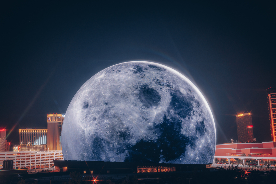 Las Vegas skyline at night with Sphere in foreground, lit up as the moon