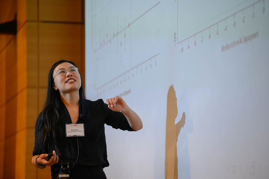 Danielle Li stands in front of projected screen, looking up at the image