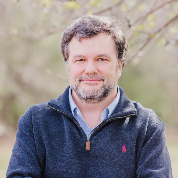 Headshot of Phil Erickson with greenery behind him
