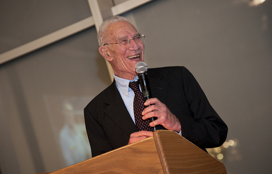 Closeup of Robert Solow speaking at a lecturn, holding a microphone, in 2011