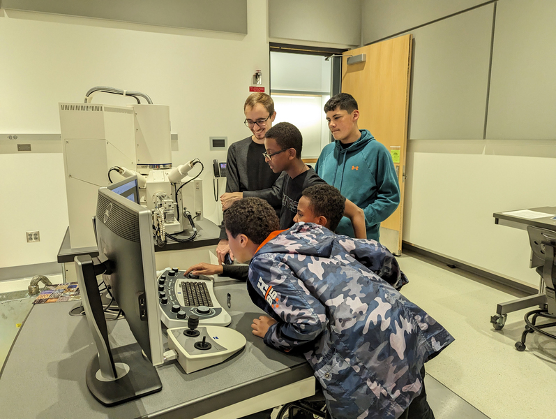 Nick Sbalbi watches four middle schoolers clustered around the computer controls of a scanning electron microscope.