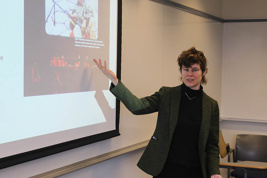 Emily Goodling gestures to a PowerPoint slide with an image of a hockey player