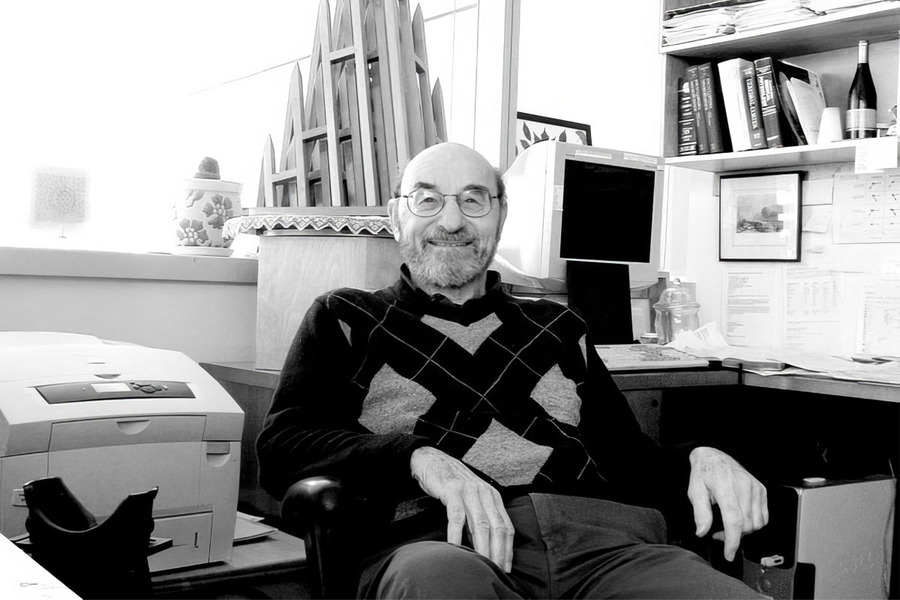 Black-and-white portrait photo of Peter Schiller seated in an armchair in front of an office desk
