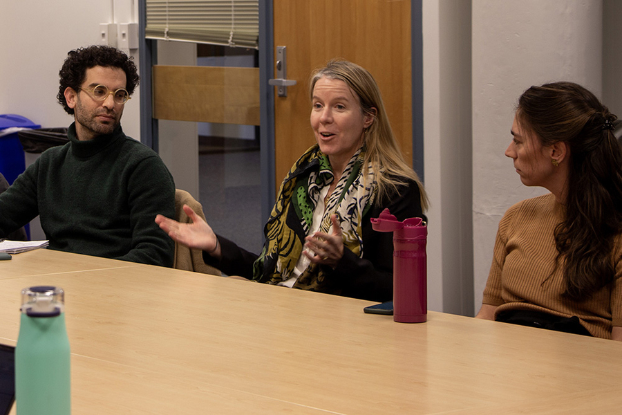 Andre Zollinger, Bethany Patten, and Marcela Angel engage in discussion at a table indoors