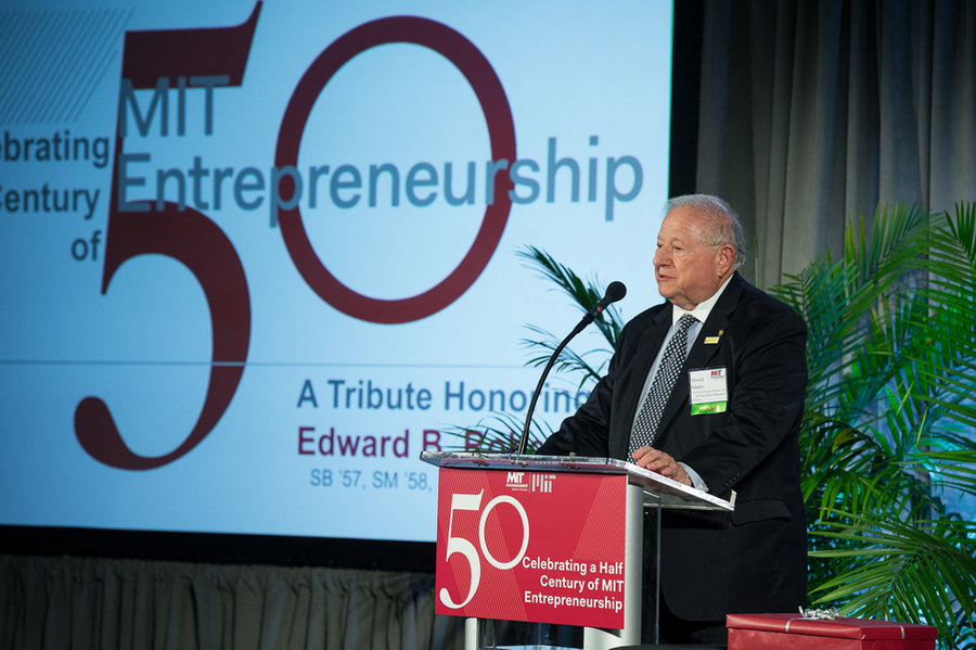 Ed Roberts speaks at a podium, and a screen behind him says, “Celebrating a half century of MIT Entrepreneurship.”