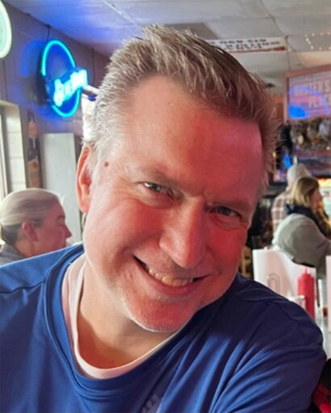 Photo of Casey Harrington smiling while at a restaurant.