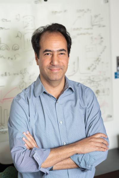 Portrait photo of Alan Jasanoff in front of a wall covered with equations