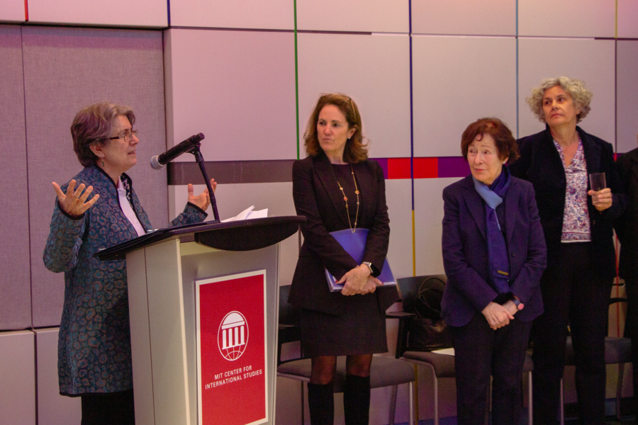 Elizabeth Wood speaks at a lectern while Cynthia Barnhart, Suzanne Berger, and Pascale Laborier look on