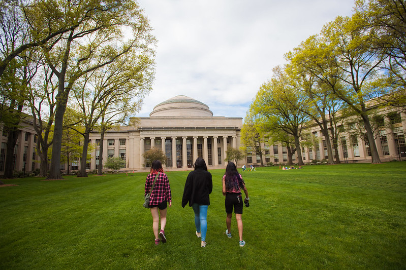 three students walking in Killian Court on a spring day