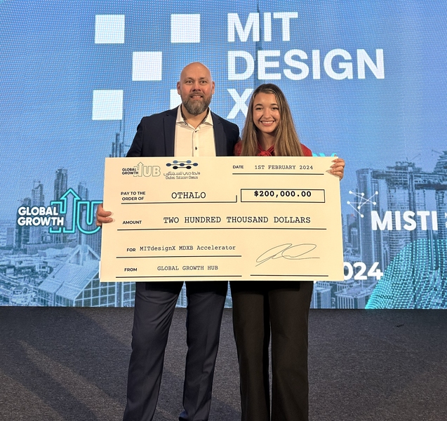 Man and woman hold an oversized promotional bank check for $200,000