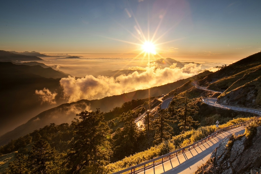 Photo of the sun rising over a mountaintop road in Taiwan.