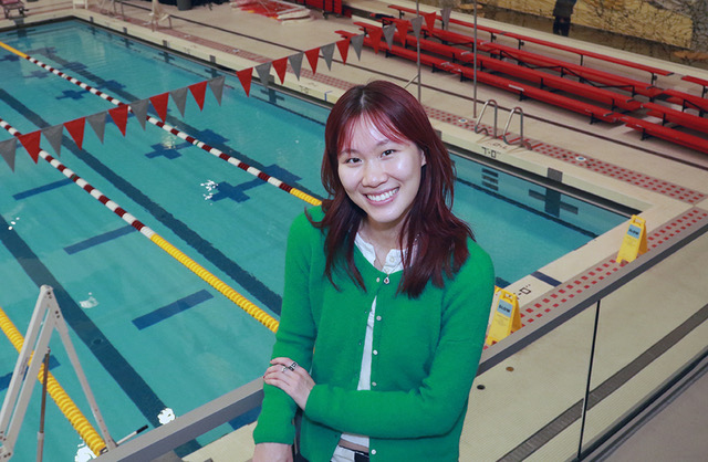 Daisy Wang poses in front of an indoor pool