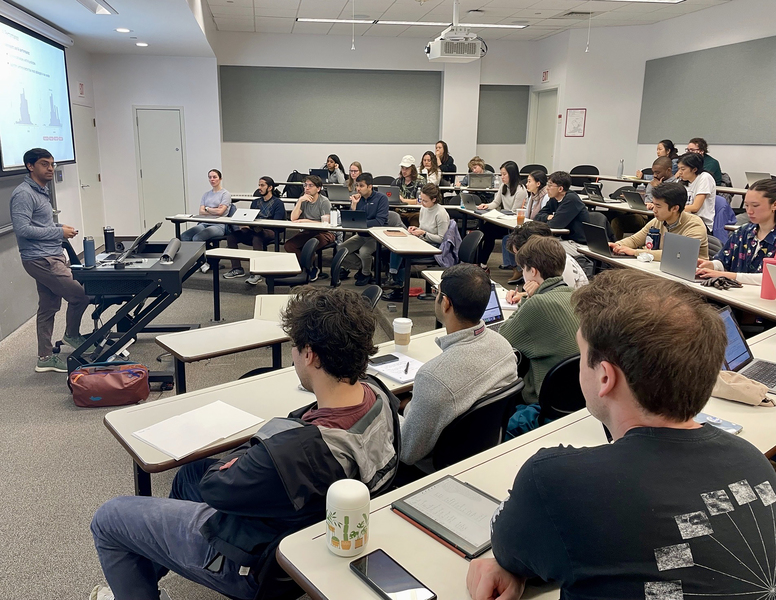 Photo of a mostly-full classroom in which Ashesh Rambachan, standing at left, leads a discussion.