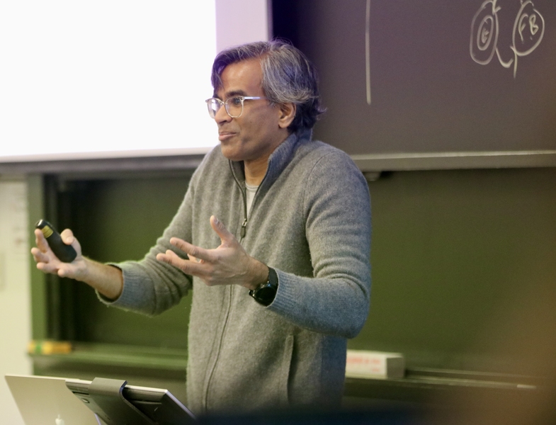 Sendhil Mullainathan stands in front of a classroom, gesturing with both hands