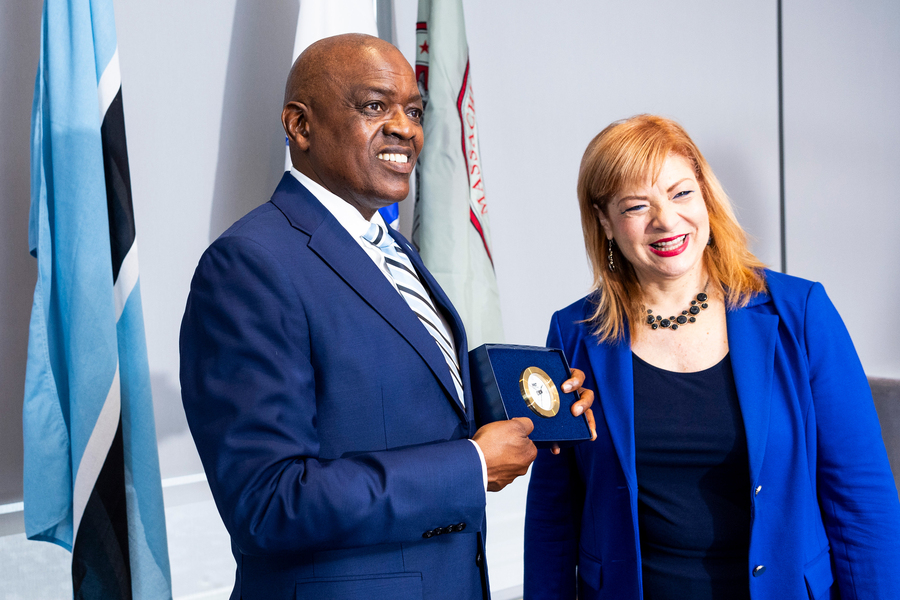 President Masisi and Georgia Perakis pose for a photo while Masisi holds an MIT clock.