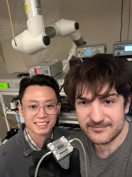 Jia Xu Brian Sia and Luigi Ranno smile for a selfie while holding the photonic chip sensor.