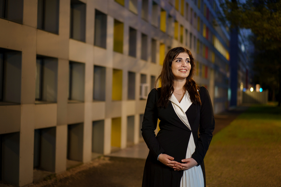 Peggy Ghasemlou looks to the side while posing for portrait at MIT campus at nighttime.