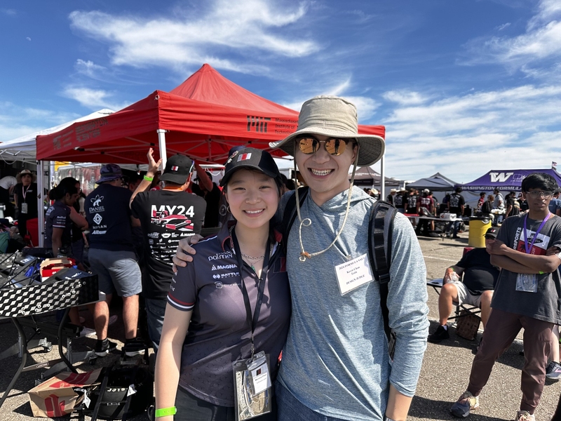 Monica and Kevin Chan in front of a red MIT tent 