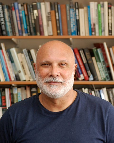 Owen Coté in front of bookshelves